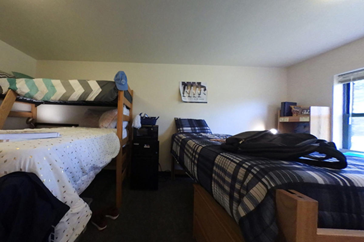 A neatly organized dorm room with two beds, appliances, and personal items.