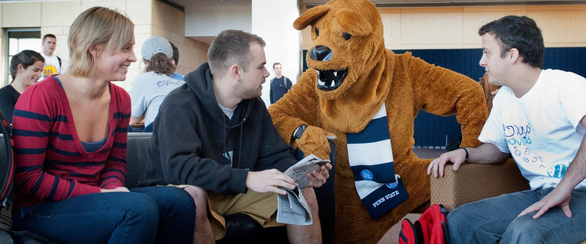 students sitting in chairs talking to each other and Nittany Lion Mascot