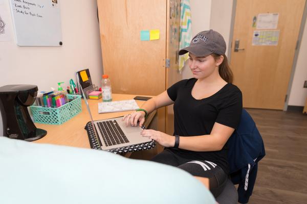 Student at her desk in Orchard Hall double room