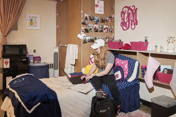 Student working on her laptop in her room 