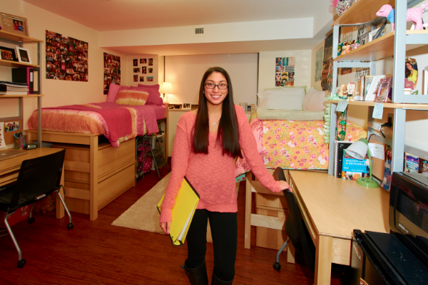 student standing in residence hall room
