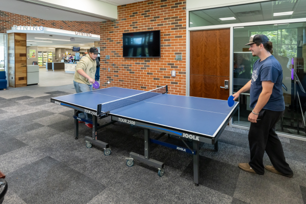 Two students playing ping pong