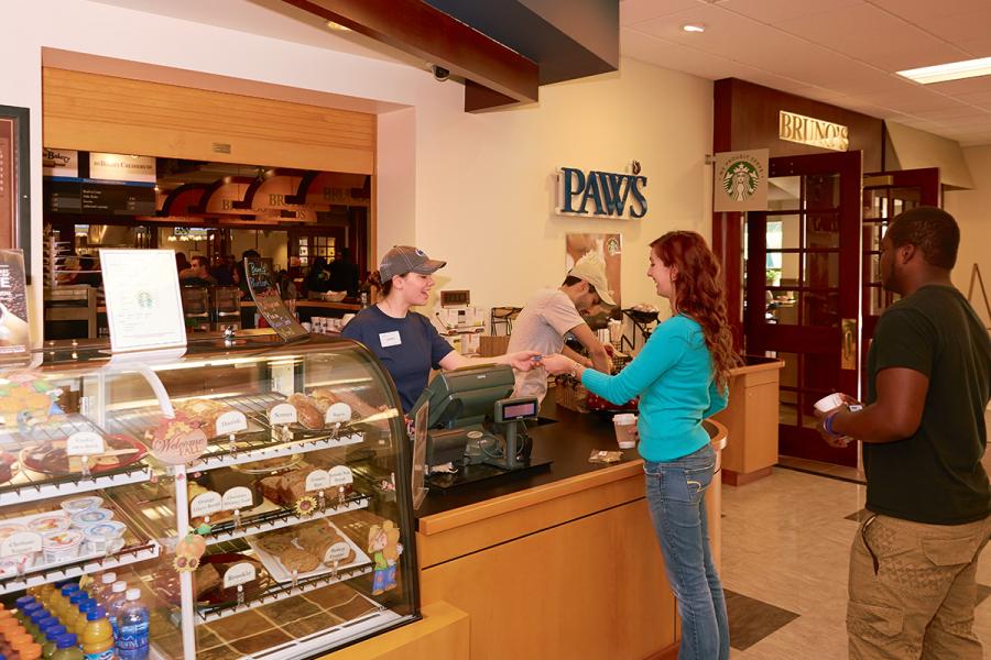 Student being helped by cashier at Paw's Coffee Shop