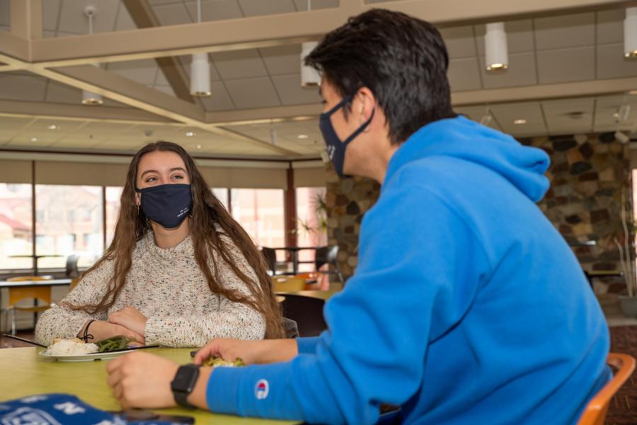 students at a table with masks on