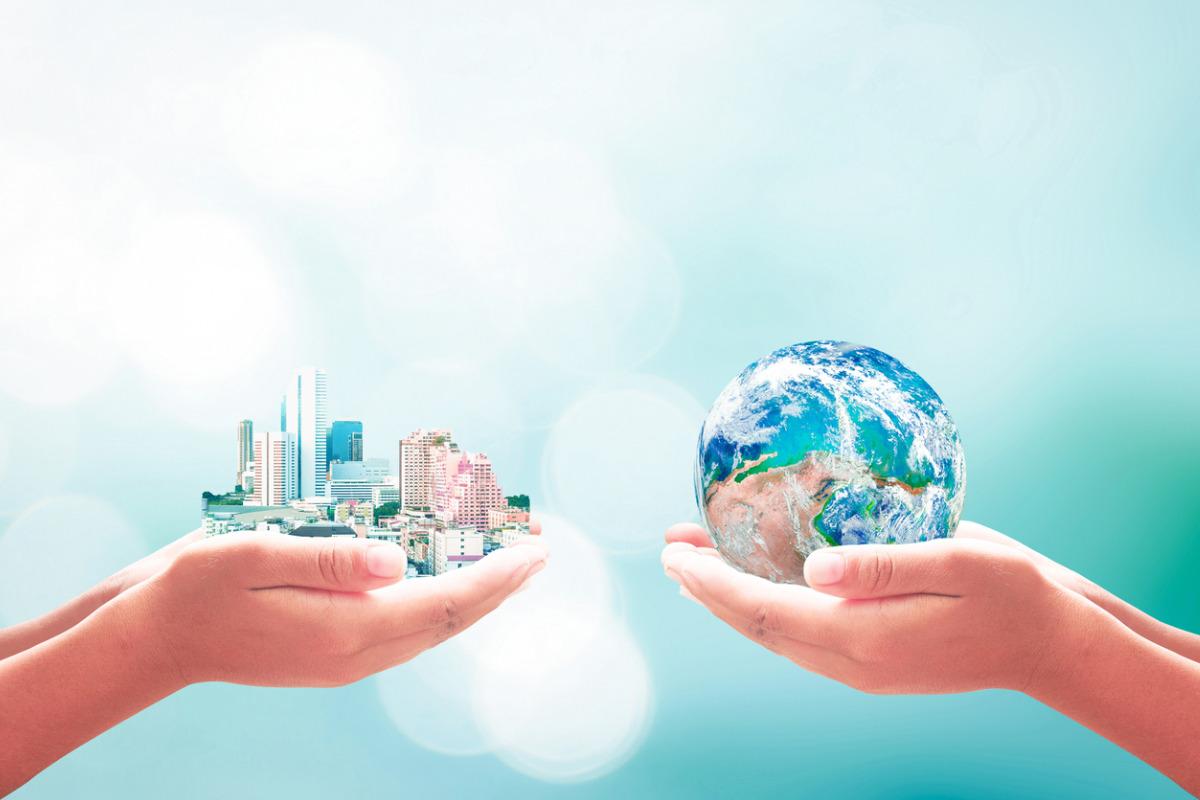 illustration of one hand holding a city and another hand holding the earth