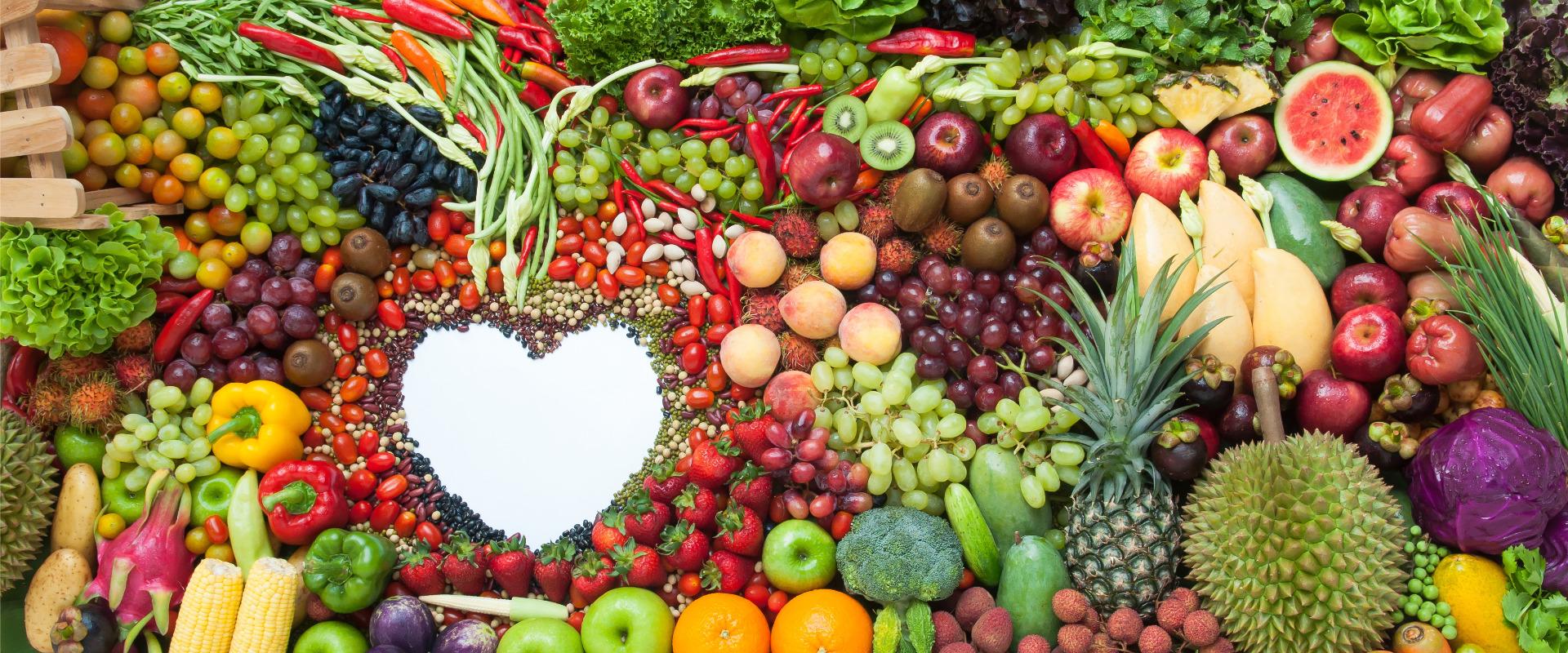 fruits veggies and nuts surrounding white space in shape of heart
