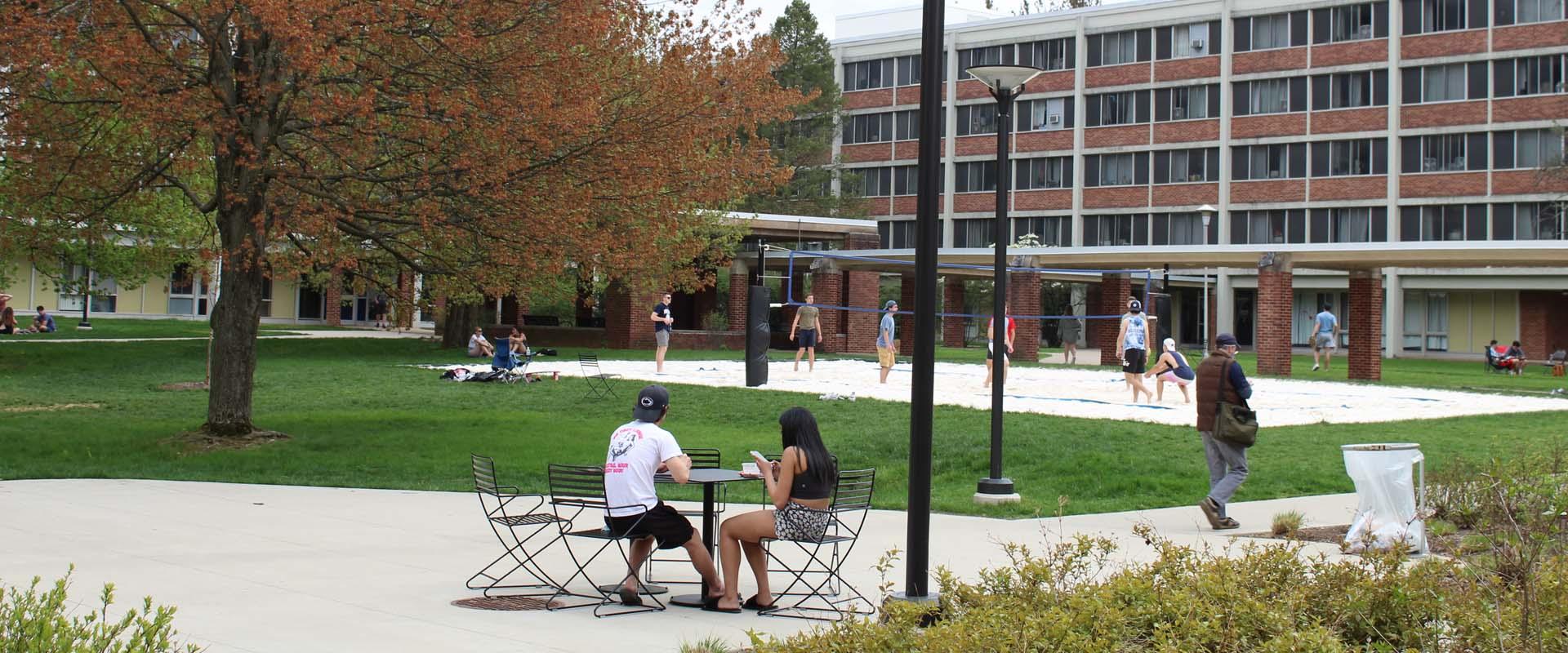 two students sitting at a table in the quad