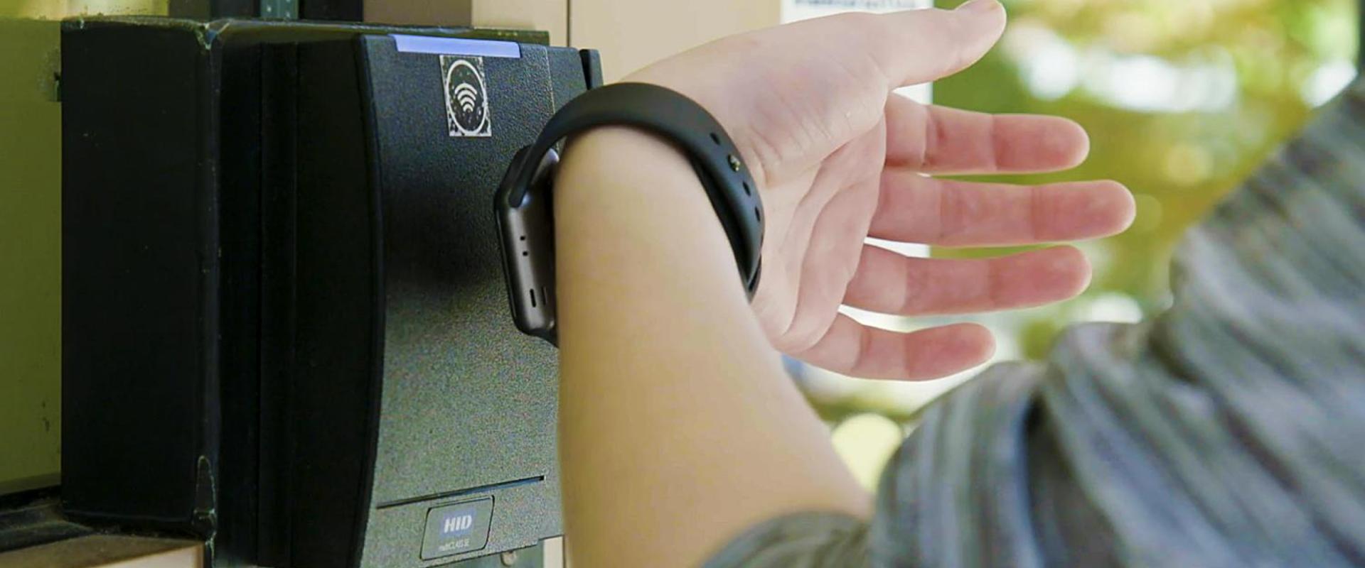 A student uses her smart watch to access her residence hall. 