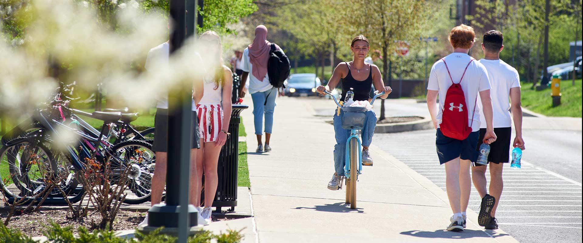 student bicycles across campus