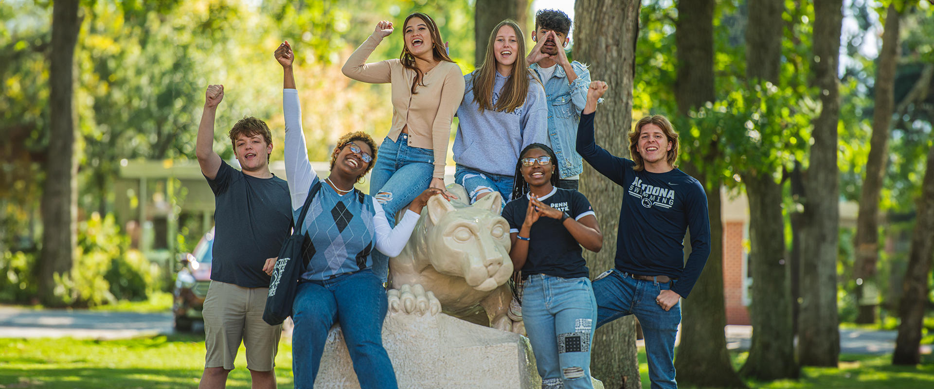 Penn State Altoona students pose for a picture at the campus lion shrine