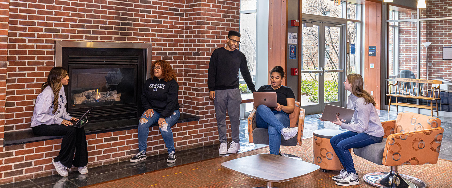 Students gathered by the fireplace in the student lounge